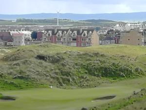 a view of a golf course with houses on a hill at Links Vista Portrush in Portrush
