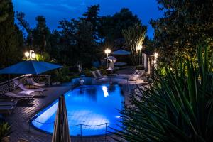 a pool at night with chairs and umbrellas at Ischia Dream Sunset in Ischia