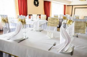 Hotel Zumrat في كاراغاندي: طاولة مع مفارش المائدة البيضاء والمناديل والأواني