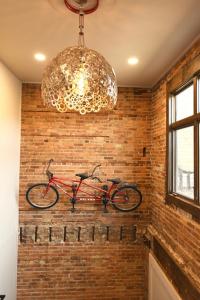 a bike hanging on a brick wall with a chandelier at Crosby Lofts in Crosby