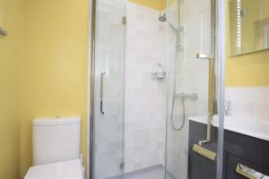 a bathroom with a shower and a toilet and a sink at B&B@no2 in Sheringham