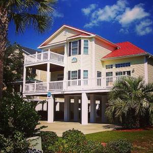 una grande casa bianca con un ampio balcone di Seven Palms a Myrtle Beach