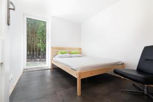1 dormitorio con 1 cama, 1 silla y 1 ventana en Naturalny domek z banią ruską, en Siedliszcze