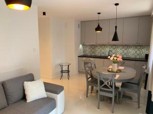 a kitchen and living room with a table and a couch at Apartament Zacisze Rose Gold in Malbork