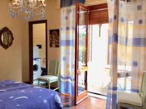 Schlafzimmer mit einem Bett, einem Fenster und einem Kronleuchter in der Unterkunft Sky Room in Sanremo