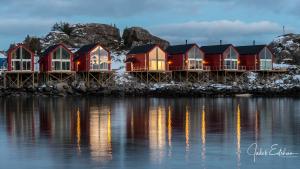 una fila de casas en un muelle junto al agua en Lofotveggen Panorama en Ballstad