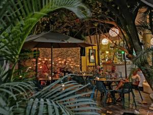 a restaurant with tables and chairs and a brick wall at Coco Tulum Zen Zone Hotel in Tulum