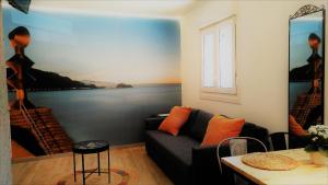 a man sitting on a couch next to a painting at Kaixo Family in Zarautz