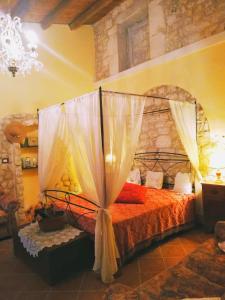 a bedroom with a large bed with a canopy at Torre Rodosta in Modica