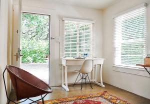 オースティンにあるHotel San Joseのデスク、椅子、窓が備わる客室です。