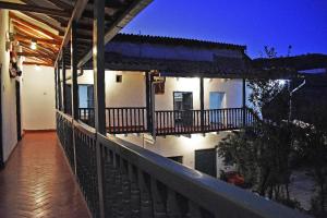 un balcón de una casa con una valla y luces en La Estacion San Pedro, en Cusco