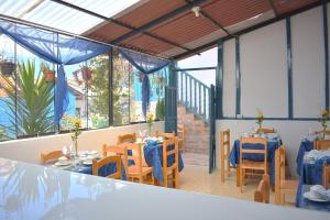 a restaurant with blue tables and chairs and windows at La Estación San Pedro in Cusco