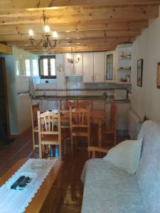 uma cozinha e sala de jantar com uma mesa e um sofá em Casa Valentina em Villar de Otero