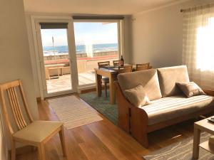 a living room with a couch and a table and chairs at Caravela in Perafita