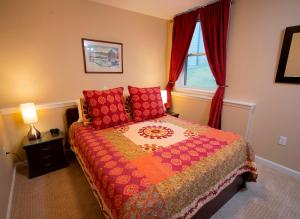 a bedroom with a bed with red pillows and a window at Winterplace 3 Br- Plenty Of Bedding- Great For Families Condo in Ludlow