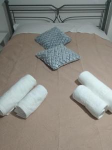 a bed with four rolled up towels on it at Vassiliki Limnos in Áyios Dhimítrios