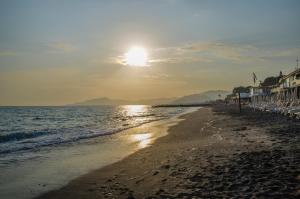 uma praia com o sol nascendo sobre o oceano em A casa di Anna em Lavagna