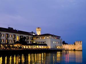 a building with a clock tower on top of the water at Grand Hotel Terme Sirmione in Sirmione