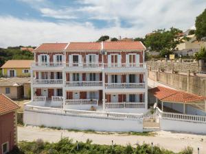 a large white house with a red roof at Pernari Apartments in Spartià