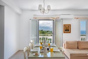 a dining room with a table and a couch at Pernari Apartments in Spartià