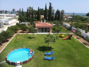 an aerial view of a backyard with a pool and playground at Marathon Beachside Villa 100m from the beach in Schinias