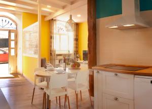 cocina con paredes amarillas, mesa y sillas en TALA FLAT, en Lekeitio