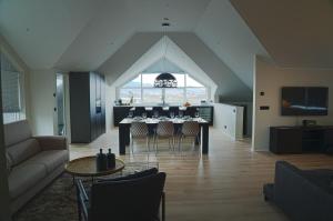 a living room with a dining table and a kitchen at Om Apartments in Reykjavík