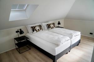 a bedroom with a bed with two dogs on the pillows at Om Apartments in Reykjavík