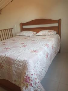 uma cama com um edredão branco e 2 almofadas em Loft Holambra em Holambra