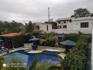 a resort with a pool with umbrellas and a building at Villa el despertar azul in Same