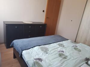 a small bedroom with a bed and a dresser at Apartament Puck in Puck +3 photos