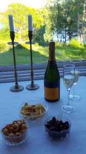 una mesa con una botella de vino y tazones de comida en Villa Nyborg - By the Sea, en Estocolmo