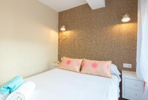 sypialnia z białym łóżkiem z 2 różowymi poduszkami w obiekcie Cozy Loft Near The Beach w mieście Torremolinos
