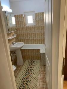 a bathroom with a sink and a tub and a toilet at Apartament Port Turistic Mangalia in Mangalia
