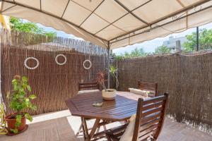 drewniany stół i krzesła pod parasolem na patio w obiekcie Cozy Loft Near The Beach w mieście Torremolinos