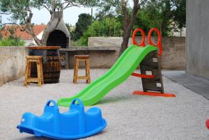 a playground with a green slide in the sand at Vacation home Kairos in Sumartin