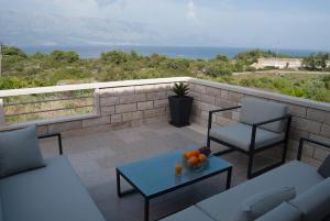 a patio with two chairs and a table with oranges on it at Vacation home Kairos in Sumartin