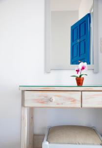 un escritorio con un jarrón con una flor en LALOS Rooms en Parikia