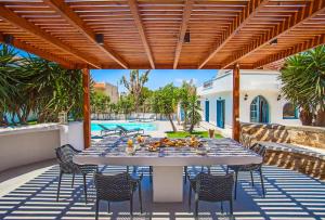 a patio with a table and chairs and a pool at Bella Foresta Villa II in Rhodes Town