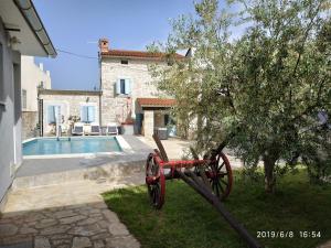 a red wagon in a yard next to a house at Holiday Home Peruski in Peruški