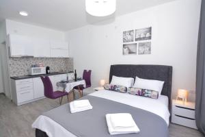 a small bedroom with a bed and a kitchen at Small Oasis Apartment in Tivat