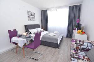a hotel room with a bed and a table and chairs at Small Oasis Apartment in Tivat