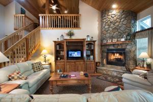 a living room with a stone fireplace and couches at 2A The Terry Cabin in North Wawona