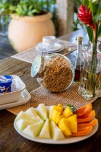 une table avec une assiette de fruits et un bol de noix dans l'établissement Ilhabela Homestay, à Ilhabela