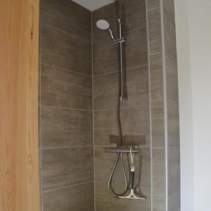 een douche met een douchekop in de badkamer bij Brakkerhus in Egtved