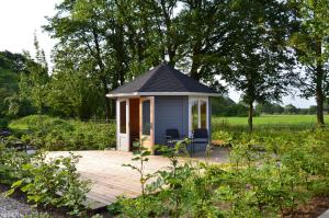 - un kiosque sur une terrasse en bois dans un jardin dans l'établissement Brakkerhus, à Egtved