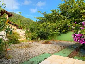 a garden with flowers and trees and a building at AymuraY Hostel e Pousada in Penha