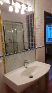 a bathroom with a white sink and a mirror at Siesta Apartments in Sopot +19 photos