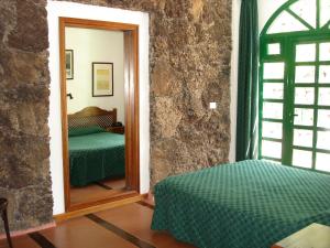 a bedroom with a mirror and a bed in a room at Hotel Ida Inés in Frontera