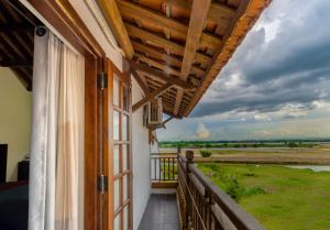 un balcón de una casa con vistas a un campo en Calm House Hotel Hoi An 1 en Hoi An